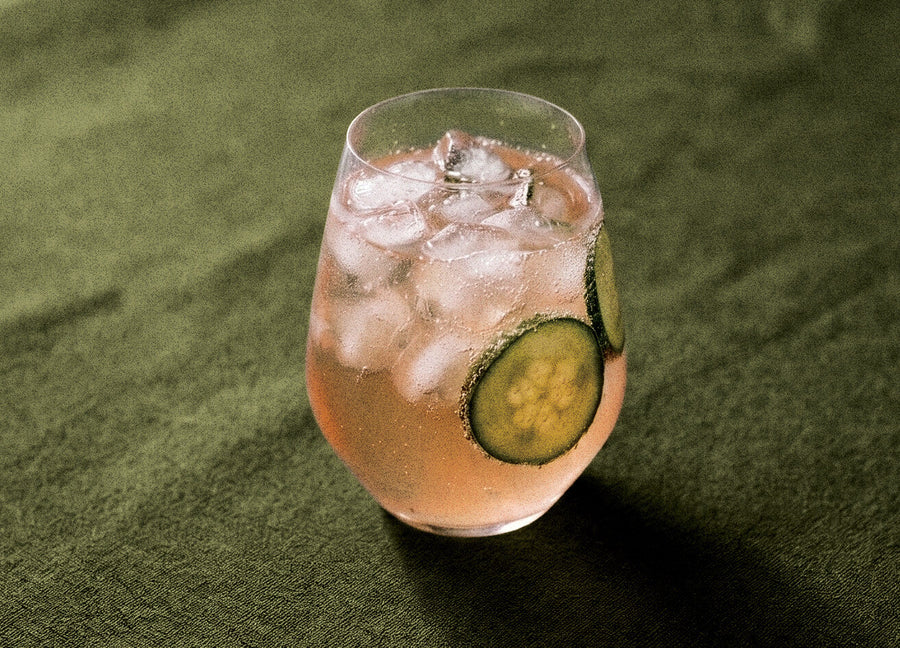 Citrus Breeze cocktail made with Humdinger Citrus Gin, served over ice with cucumber slices on green linen